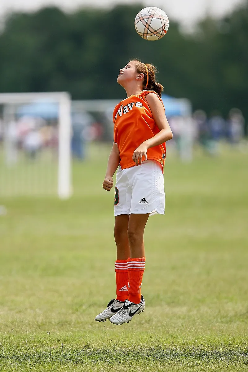 Original photo of a young soccer player heading the ball